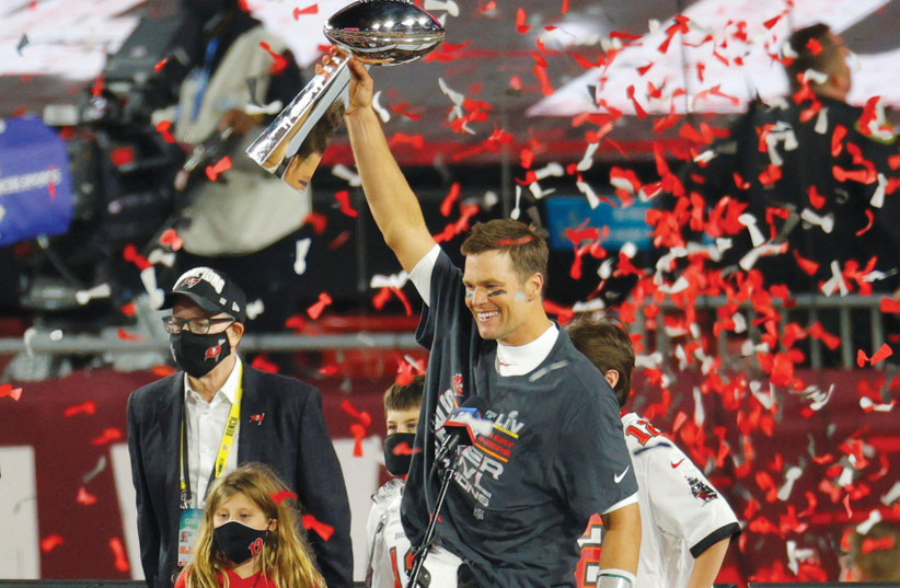  TAMPA BAY BUCCANEERS’ Tom Brady celebrates with the Vince Lombardi trophy after winning Super Bowl LV a year ago.  (credit: BRIAN SNYDER/REUTERS)