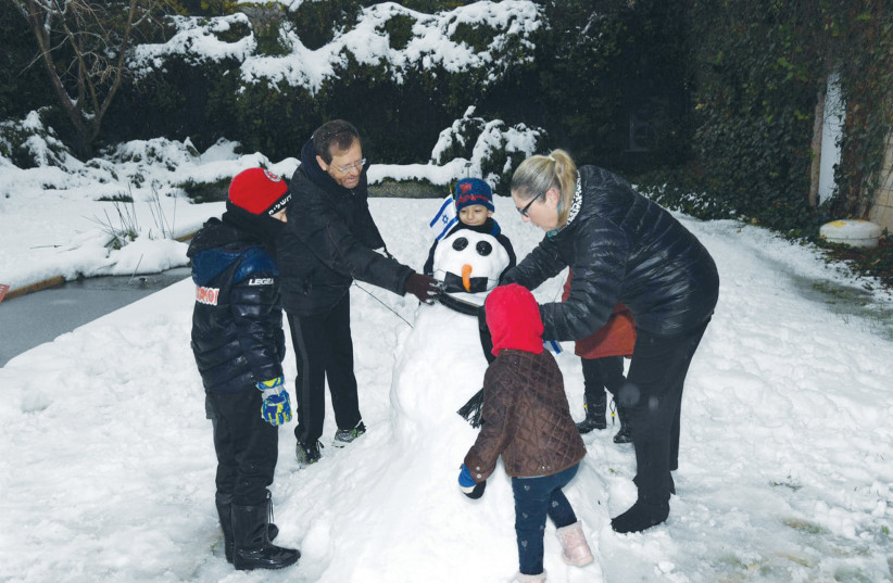  PRESIDENT ISAAC Herzog and his wife, Michal, build a snowman after last week’s snowfall in Jerusalem. (photo credit: HAIM ZACH/GPO)
