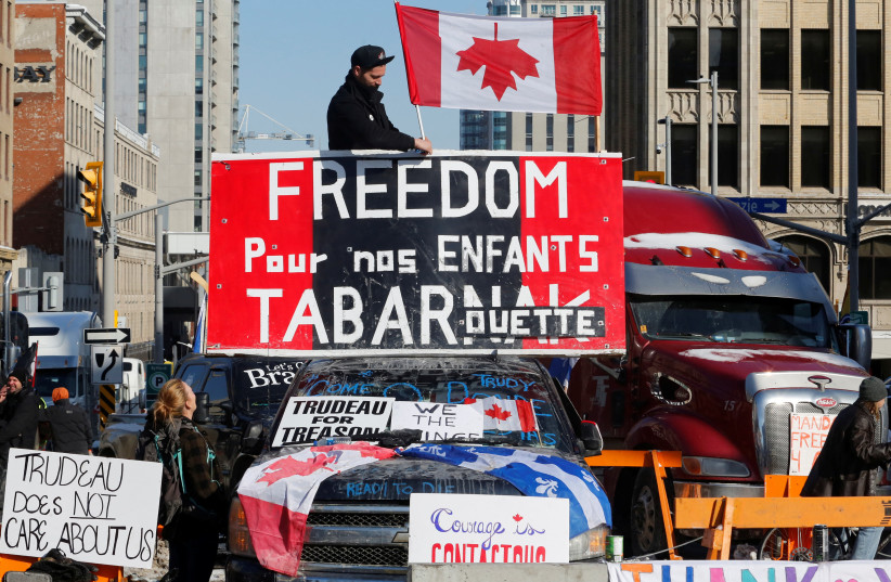  A person attaches a flag to a truck as truckers and their supporters continue to protest coronavirus disease (COVID-19) vaccine mandates, in Ottawa, Ontario, Canada, February 7, 2022. (photo credit: PATRICK DOYLE)