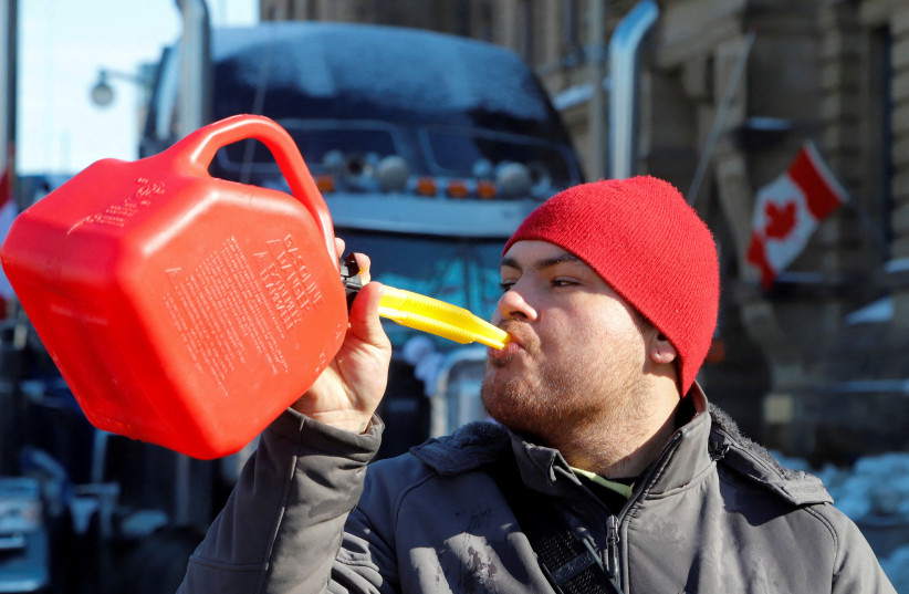  A person pretends to drink from a fuel can after police said they will be targeting the truckers' fuel supply as truckers and their supporters continue to protest coronavirus disease (COVID-19) vaccine mandates, in Ottawa, Ontario, Canada, February 7, 2022. (credit: PATRICK DOYLE)