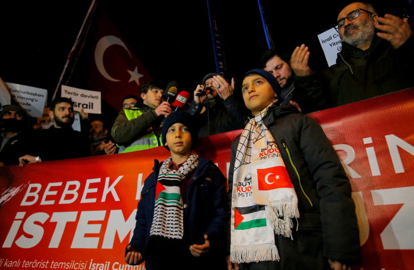  Demonstrators pray during a protest against a prospective visit by Israel's President Isaac Herzog, outside the Israeli Consulate in Istanbul, Turkey January 31, 2022. The banner reads: ''We don't want baby killers in our country''.  (credit: DILARA SENKAYA/REUTERS)