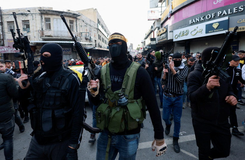  Armed men look on during a funeral following the shooting of three Palestinian gunmen who were killed by Israeli forces, in Nablus, in the West Bank, February 8, 2022 (photo credit: MOHAMAD TOROKMAN/REUTERS)