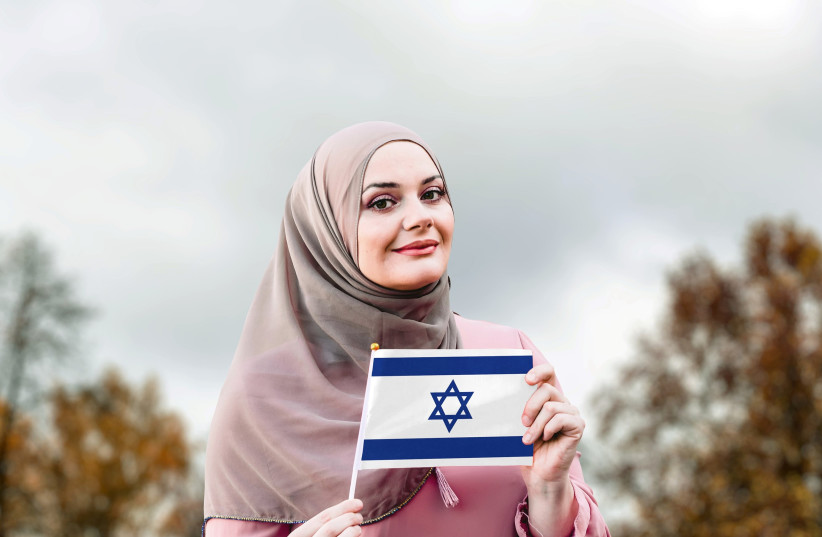  Muslim woman holding Israeli flag (photo credit: Shutterstock / Hananya Naftali)