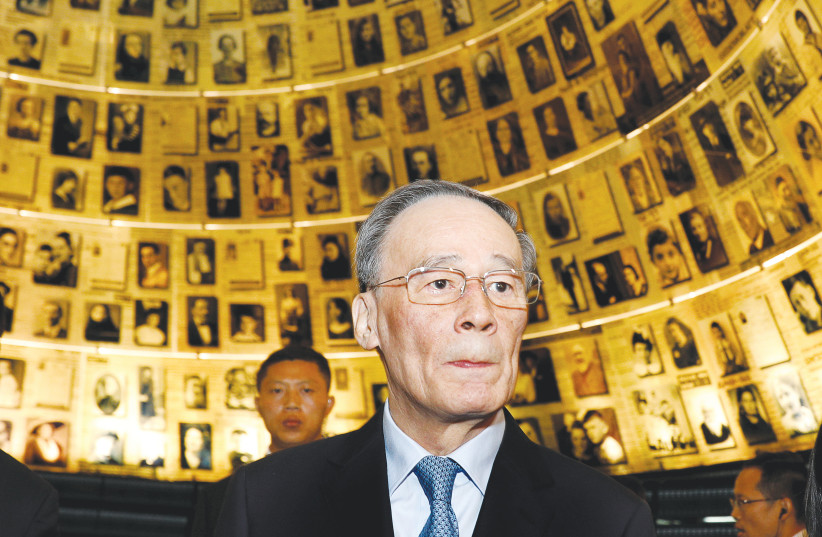 Chinese Vice President Wang Qishan looks at pictures of Jews killed in the Holocaust during a visit to Yad Vashem’s Hall of Names in 2018. (photo credit: GALI TIBBON)
