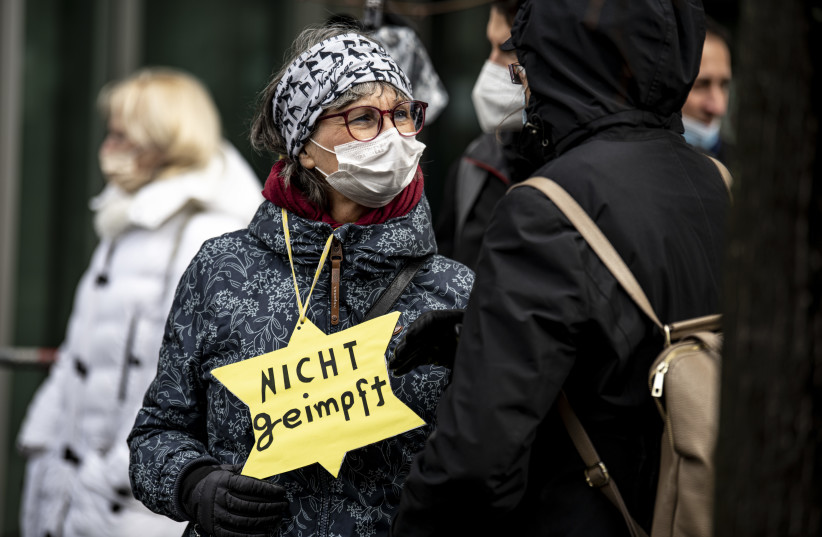 A participant in a demonstration against Coronavirus restrictions stands with a yellow star with the inscription "not vaccinated" in Berlin, March 13, 2021.  (photo credit: Fabian Sommer/picture alliance via Getty Images)