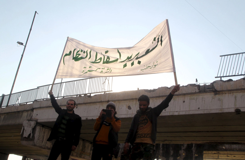  People carry a banner while attending a protest against forces loyal to Syria's President Bashar al-Assad, Russia and the Syrian Democratic forces, in Tariq al-Bab neighbourhood of Aleppo, Syria February 29, 2016.  (photo credit: REUTERS/ABDALRHMAN ISMAIL)