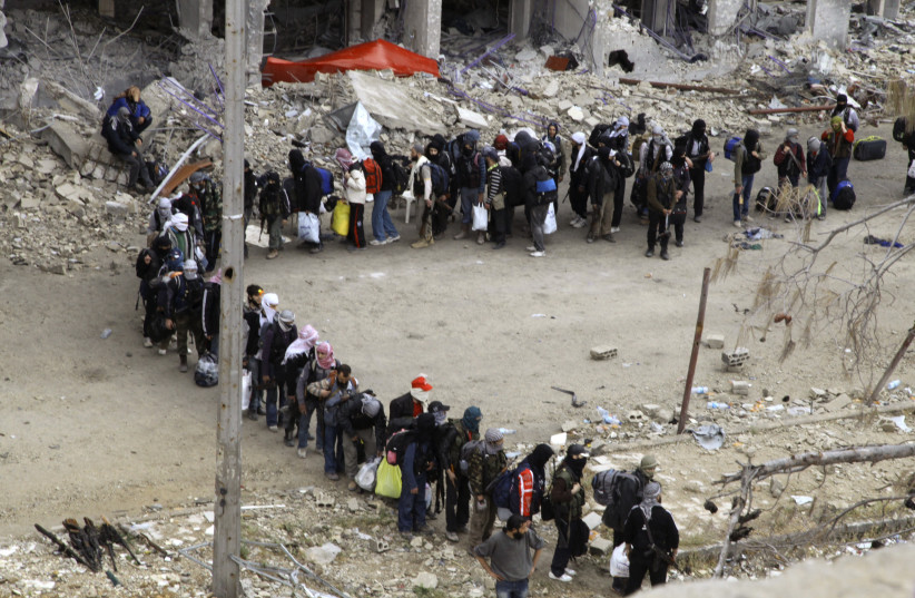  Rebel fighters queue as they wait to be evacuated from the Old City of Homs May 8, 2014.  (credit: REUTERS/GHASSAN NAJJAR)