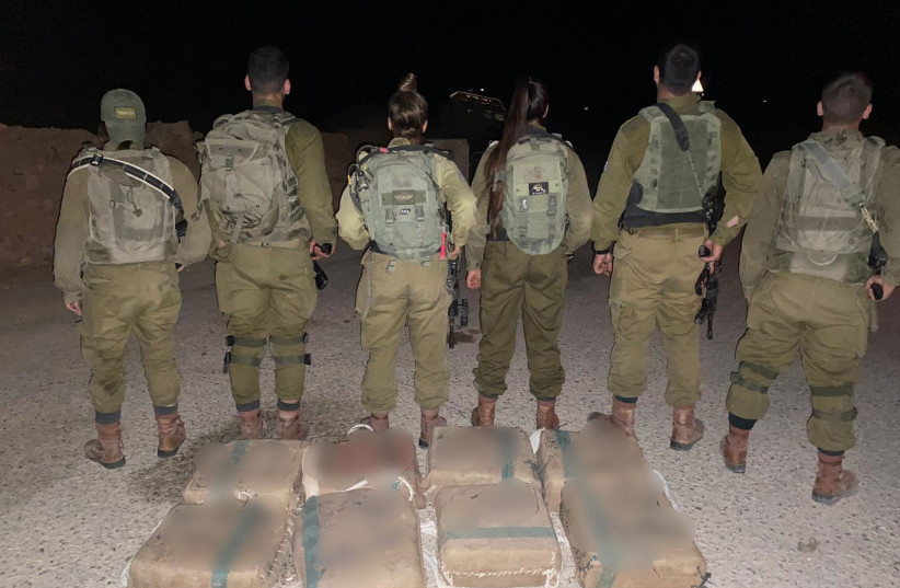 IDF soldiers are seen with seized illegal drugs in the Negev in Israel's South. (credit: IDF SPOKESPERSON'S UNIT)