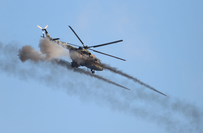 A helicopter fires during military exercises held by the armed forces of Russia and Belarus at the Gozhsky training ground in the Grodno region, Belarus, in this handout photo released February 12, 2022. (photo credit: LEONID SCHEGLOV/BELTA/HANDOUT VIA REUTERS)