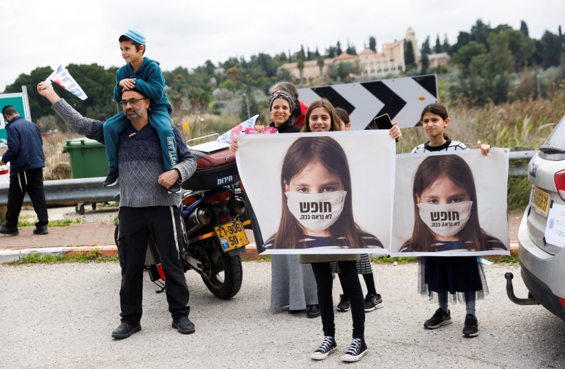  Children hold signs which read ''freedom doesn't look like this'' as part of a protest before heading to Jerusalem as part of an Israeli ''Freedom Convoy'', to protest against restrictions to contain the spread of the coronavirus disease (COVID-19), in Latrun, Israel, February 14, 2022. (credit: AMIR COHEN/REUTERS)