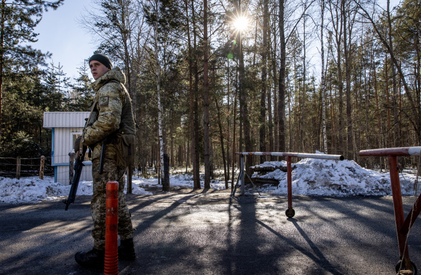  A member of the Ukrainian State Border Guard stands watch at the border crossing between Ukraine and Belarus, Feb. 13, 2022. (photo credit: Chris McGrath/Getty Images/JTA)
