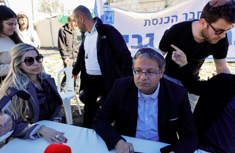  Israeli lawmaker Itamar Ben Gvir sits at a table as Palestinian protesters clash with Israeli security forces in Sheikh Jarrah, East Jerusalem, February 13, 2022.  (credit: REUTERS/AMMAR AWAD)