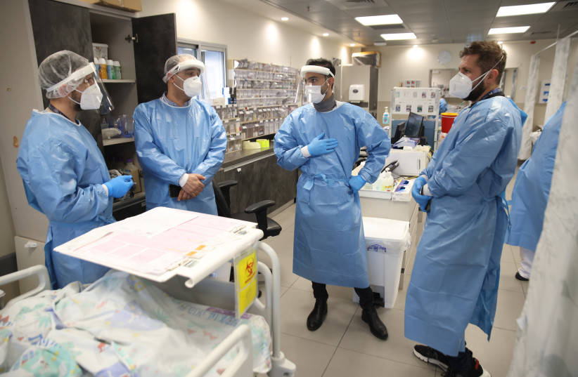 Ziv hospital team members wearing safety gear as they work in the Coronavirus ward of Ziv Medical Center in the northern Israeli city of Tzfat on February 15, 2022.  (credit: DAVID COHEN/FLASH 90)