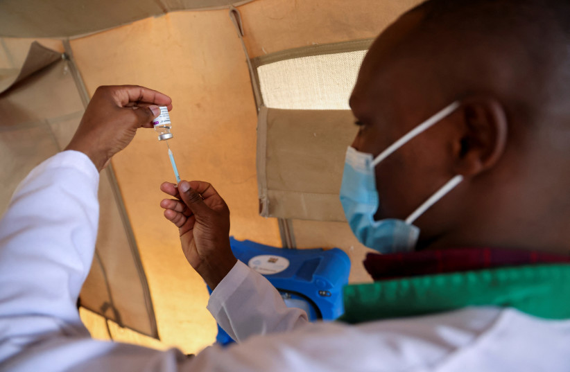  A healthcare professional prepares a dose of AstraZeneca (COVID-19) vaccine at the Narok County Referral Hospital, in Narok, Kenya, December 1, 2021. Picture taken December 1, 2021.  (photo credit: BAZ RATNER/REUTERS)