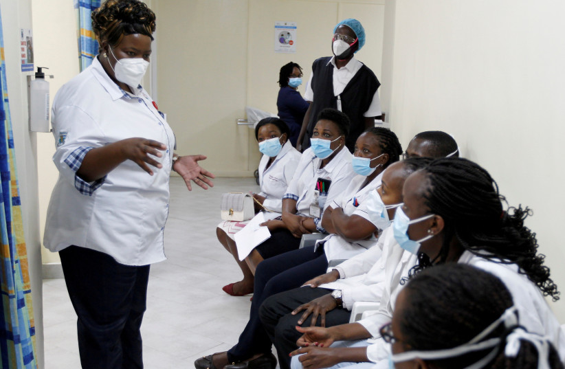  A health worker talks to her colleagues as they prepare to receive the AstraZeneca/Oxford vaccine under the COVAX scheme against coronavirus disease (COVID-19) at the Kenyatta National Hospital in Nairobi, Kenya March 5, 2021. (credit: MONICAH MWANGI/REUTERS)