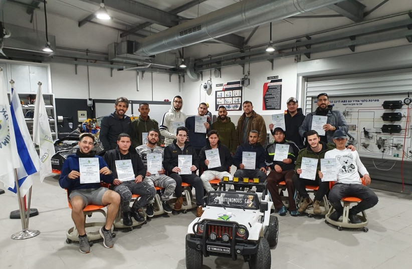  Moshe Uziel (first from the left, top row) and students of the AMIT Zeisels Pre-Army Junior College at AMIT Kfar Blatt, Petach Tikva, with the autonomous vehicle they built (credit:  Liraz Lugsi)