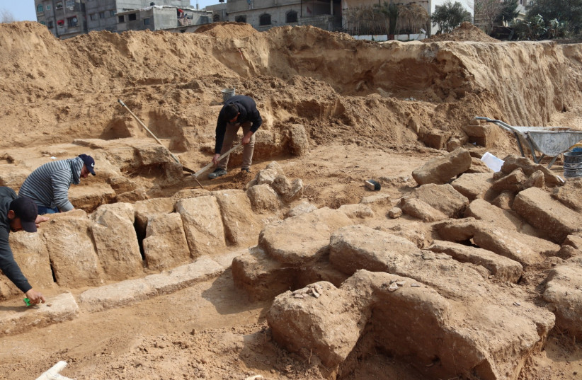  Men work in a newly discovered Roman cemetery in Gaza, in this handout photo obtained by Reuters, February 17, 2022. (photo credit: REUTERS)