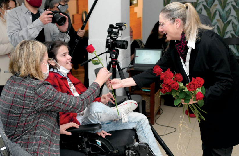  FIRST LADY Michal Herzog distributes roses at House of Wheels. (photo credit: AMOS BEN GERSHOM/GPO)