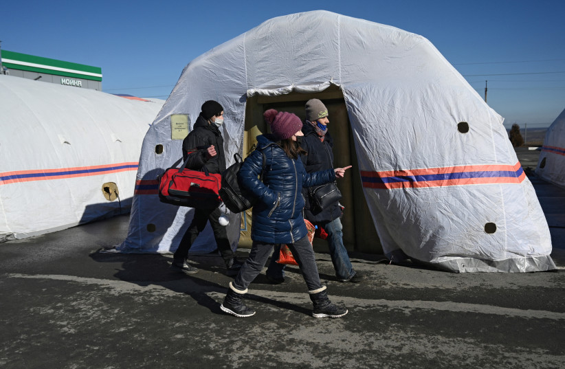  People evacuated from separatist-controlled regions in eastern Ukraine walk at a tent camp set up by the Russian Emergencies Ministry near the Matveyev Kurgan border checkpoint in the Rostov region, Russia February 19, 2022. (credit: REUTERS/SERGEY PIVOVAROV)