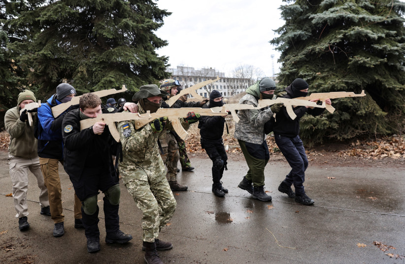  A resident learns how to point and shoot with a wooden stick as she takes part in a military exercise for civilians conducted by Christian Territorial Defence, amid threat of Russian invasion in Kyiv, Ukraine February 19, 2022. (credit: REUTERS/UMIT BEKTAS)