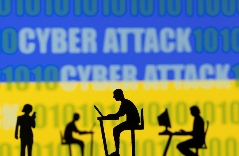  Figurines with computers and smartphones are seen in front of the words "Cyber Attack", binary codes and the Ukrainian flag, in this illustration taken February 15, 2022. (photo credit: REUTERS/DADO RUVIC/ILLUSTRATION)
