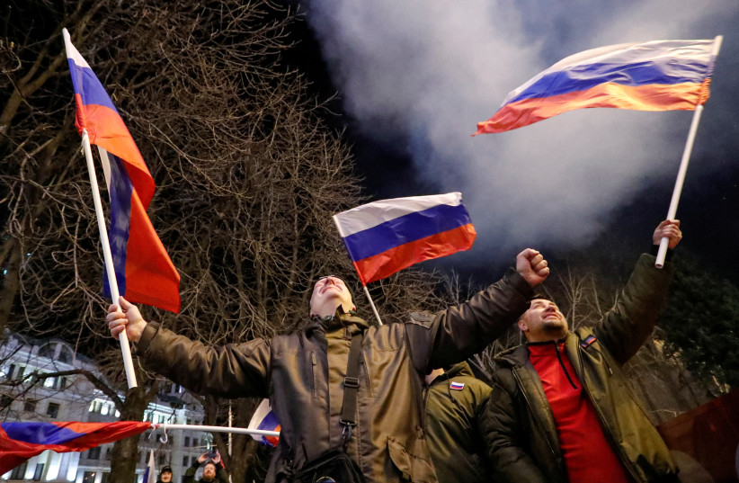  Pro-Russian activists react on a street as fireworks explode in the sky, after Russian President Vladimir Putin signed a decree recognising two Russian-backed breakaway regions in eastern Ukraine as independent entities, in the separatist-controlled city of Donetsk, Ukraine February 21, 2022. (credit: REUTERS/ALEXANDER ERMOCHENKO)