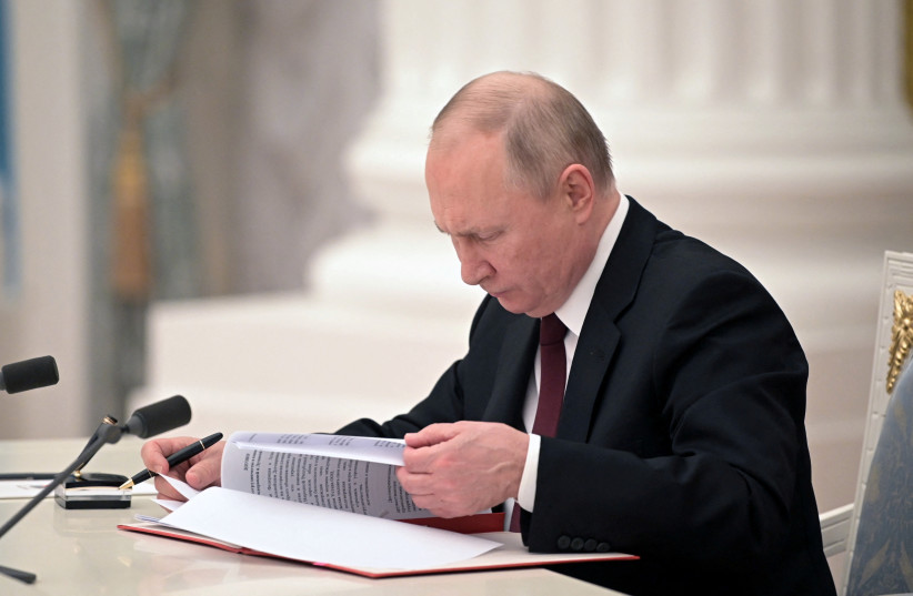 Russian President Vladimir Putin signs documents, including a decree recognising two Russian-backed breakaway regions in eastern Ukraine as independent entities, during a ceremony in Moscow, Russia, in this picture released February 21, 2022.  (credit: SPUTNIK/ALEXEY NIKOLSKY/KREMLIN VIA REUTERS)