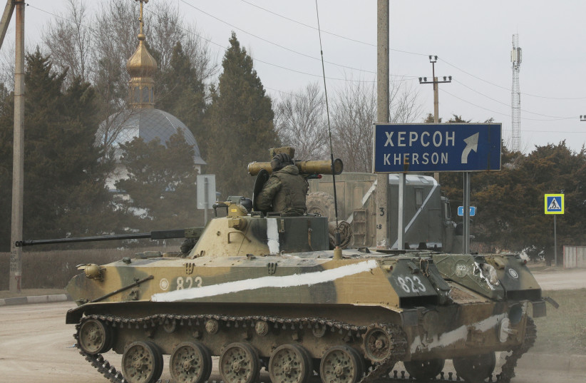  An armoured vehicle drives along a street, after Russian President Vladimir Putin authorized a military operation in eastern Ukraine, in the town of Armyansk, Crimea, February 24, 2022.  (credit: REUTERS/STRINGER)