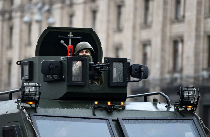  A Ukrainian serviceman rides atop a military vehicle past Independence square in central Kyiv on February 24, 2022 (credit: DANIEL LEAL/AFP via Getty Images)