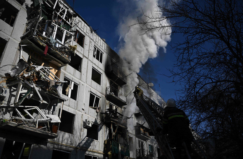 Firefighters work on a fire on a building after bombings on the eastern Ukraine town of Chuguiv on February 24, 2022 (credit: ARIS MESSINIS/AFP via Getty Images)