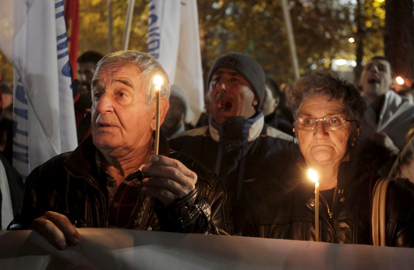  Demonstrators hold candles to commemorate the victims of NATO's 1999 bombing of Yugoslavia during an anti-NATO protest in Podgorica, Montenegro, December 12, 2015. (credit: STEVO VASILJEVIC/REUTERS)