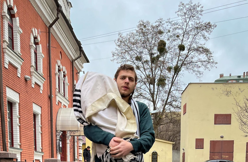  A Jewish man holds a Torah in Ukraine amidst the conflict with Russia February 24, 2022. (photo credit: UKRAINIAN JEWISH COMMUNITY)