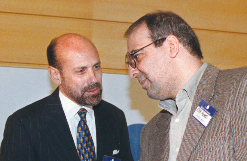  THE WRITER (left) greets his former captor, Iranian Abbas Abdi, prior to a meeting in 1998 organized by the Center for World Dialogue at the UNESCO building in Paris, nearly two decades after the takeover of the US Embassy in Tehran.  (photo credit: REUTERS)