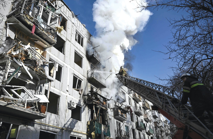  Firefighters work to put out a fire in a building after Russian bombings on the eastern Ukraine town of Chuguiv yesterday. (photo credit: ARIS MESSINIS/AFP via Getty Images)
