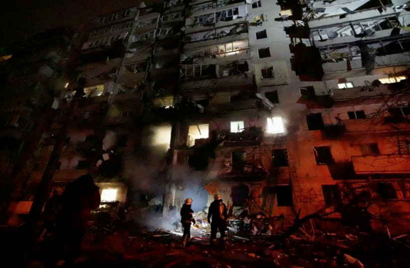  Firefighters work at the site of a damaged residential building, after Russia launched a massive military operation against Ukraine, in Kyiv, Ukraine, February 25, 2022 in this frame grab of a still image use in a video. (credit: Ukrainian Ministry of Emergencies/via Reuters TV/Handout via REUTERS)