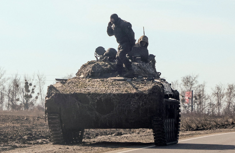 Ukrainian army soldiers are seen on an armoured vehicle, after Russian President Vladimir Putin authorised a military operation, in eastern Ukraine, in Kharkiv region, Ukraine, February 24, 2022. (credit: REUTERS/ANTONIO BRONIC)