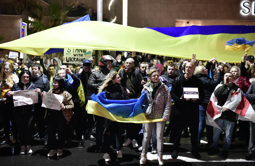  Demonstrators carry placards and flags during a protest outside the Russian Embassy in Tel Aviv, Feb. 24, 2022. (credit: TOMER NEUBERG/FLASH90)
