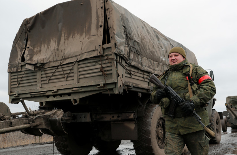  A serviceman of pro-Russian militia walks nest to a military convoy of armed forces of the separatist self-proclaimed Luhansk People's Republic (LNR) on a road in the Luhansk region, Ukraine February 27, 2022.  (photo credit: REUTERS/ALEXANDER ERMOCHENKO)