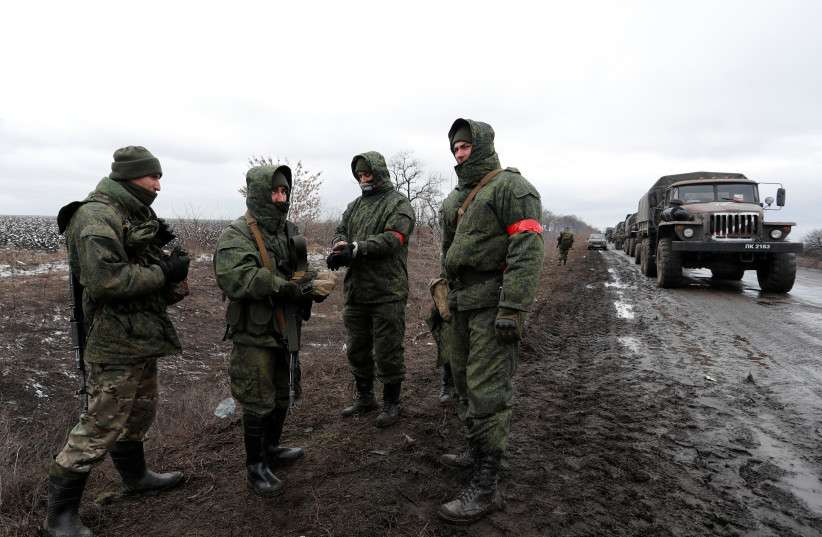  Servicemen of pro-Russian militia stand next to a military convoy of armed forces of the separatist self-proclaimed Luhansk People's Republic (LNR) on a road in the Luhansk region, Ukraine February 27, 2022. (credit: REUTERS/ALEXANDER ERMOCHENKO)