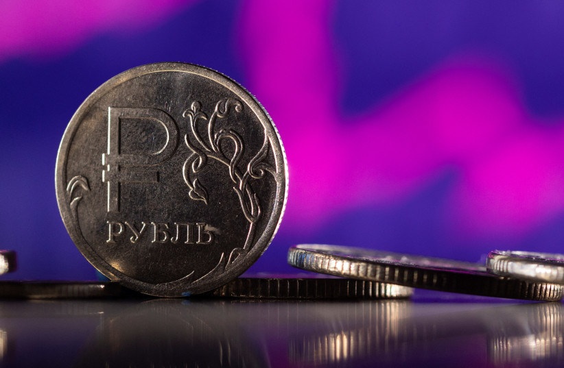  Russian Rouble coins are seen in front of displayed descending stock graph in this illustration taken, February 24, 2022. (credit: REUTERS/DADO RUVIC/ILLUSTRATION)