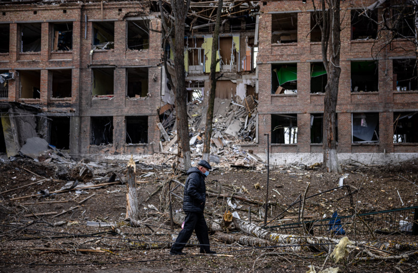 Un homme marche devant un bâtiment détruit après une attaque au missile russe dans la ville de Vasylkiv, près de Kiev, le 27 février 2022 (crédit : DIMITAR DILKOFF/AFP via Getty Images)