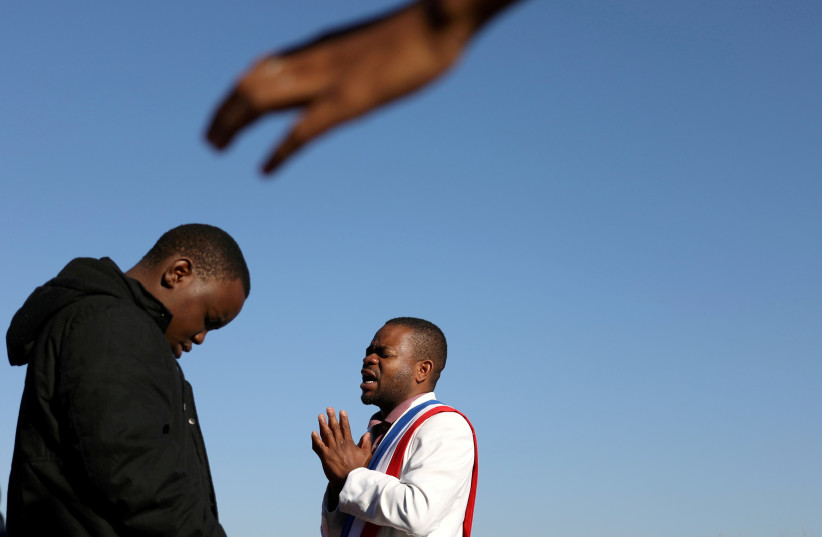  Members of The Golden Apostolic Faith Healing Mission Church pray during a religious ceremony to celebrate Good Friday in April 2021 (photo credit: SIPHIWE SIBEKO/REUTERS)