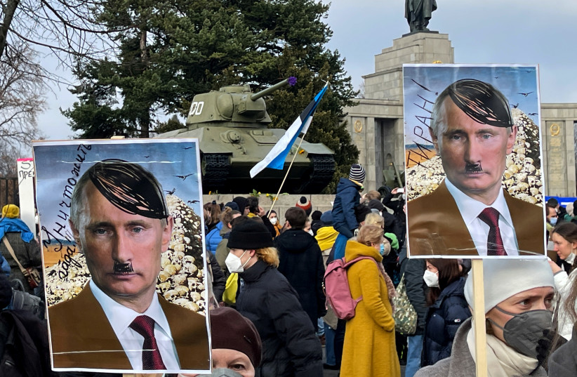  Demonstrators hold posters depicting Russian President Vladimir Putin as Adolf Hitler saying ''Tyrant'' and ''Eliminate the creep'' as they gather during an anti-war protest in front of the Soviet War Memorial at Tiergarten Park, after Russia launched a massive military operation against Ukraine, in Be (credit: REUTERS/PAWEL KOPCZYNSKI)