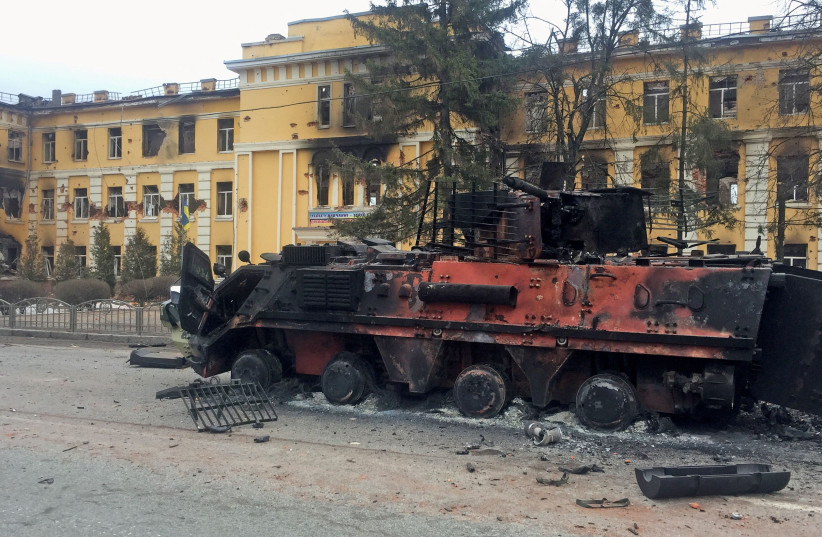  A destroyed Ukrainian armoured personnel carrier vehicle is seen in front of a school which, according to local residents, was on fire after shelling, as Russia's invasion of Ukraine continues, in Kharkiv, Ukraine February 28, 2022. (credit: Vitaliy Gnidyi/Reuters)