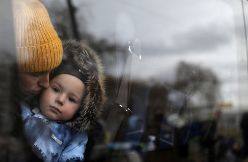  A woman and a child wait in a bus after fleeing from Russia's invasion of Ukraine, at the border crossing in Siret, Romania, March 1, 2022. (credit: REUTERS/STOYAN NENOV)