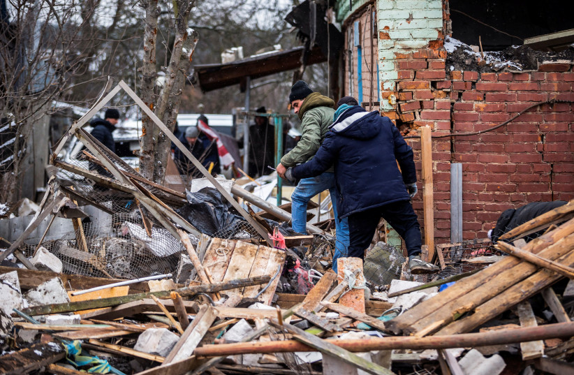 Local residents walk among debris of a residential building destroyed by shelling, as Russia's invasion of Ukraine continues, in Zhytomyr, Ukraine March 2, 2022 (photo credit: Viacheslav Ratynskyi/Reuters)
