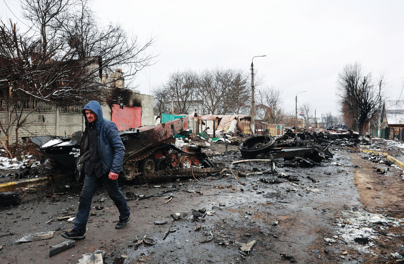  A MAN walks past destroyed military vehicles in the Kyiv region on March 1. (photo credit: Serhii Nuzhnenko/Reuters)