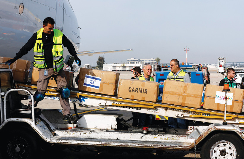  WORKERS LOAD packages of Israeli humanitarian aid destined for Ukraine, at Ben-Gurion Airport this week. (photo credit: AMMAR AWAD/REUTERS)