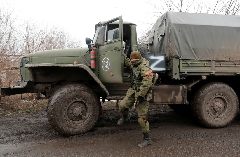  A service member of pro-Russian troops in a uniform without insignia stands next to a truck in the separatist-controlled settlement of Rybinskoye during Ukraine-Russia conflict in the Donetsk region, Ukraine March 5, 2022 (photo credit: REUTERS/ALEXANDER ERMOCHENKO)