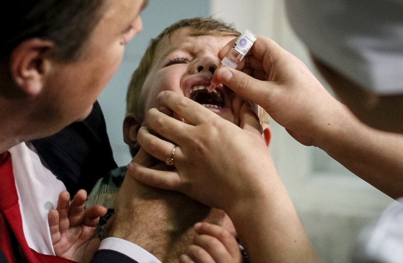  A boy receives polio vaccine drops at a clinic in Kiev, Ukraine, October 21, 2015. (credit: GLEB GARANICH/REUTERS)